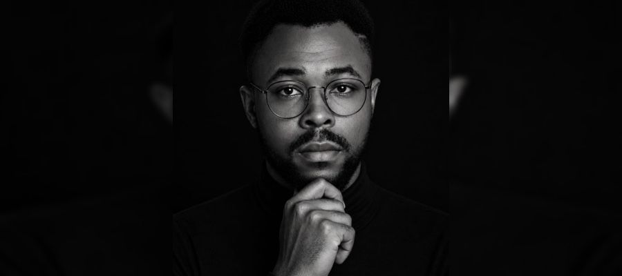 Jason Charles in a black turtleneck, chin resting on his fist